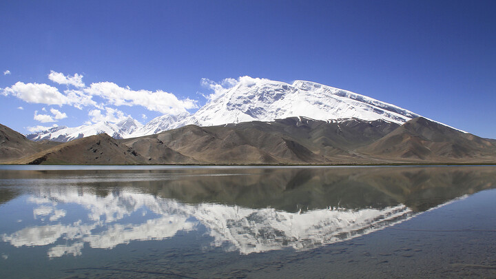 The peaks of Mt. Muztagh-Ata reflected in Lake Karakul