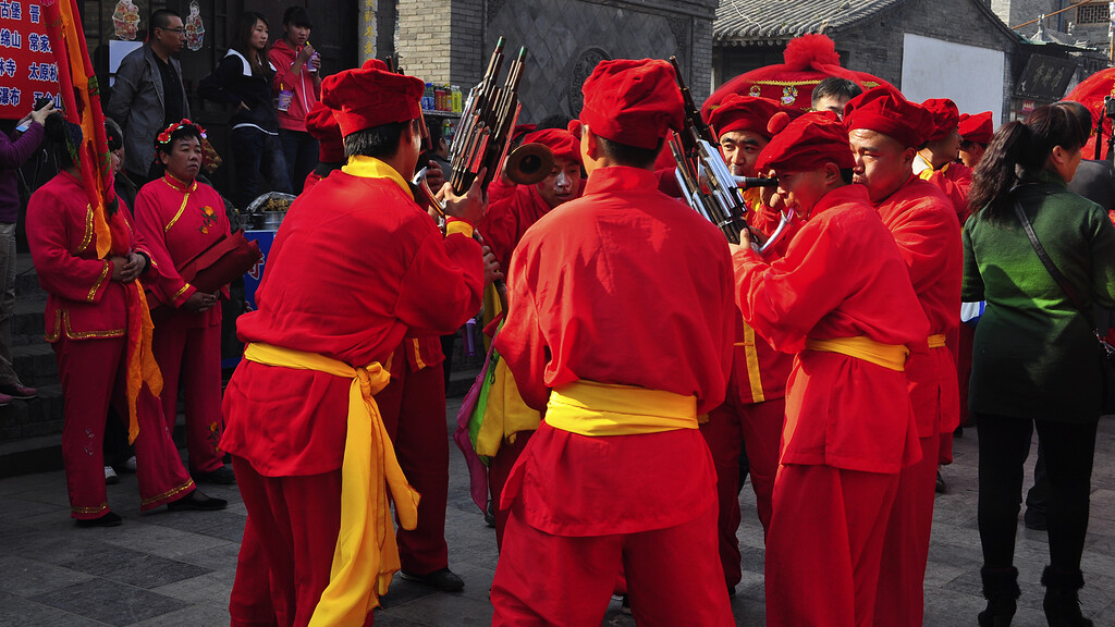 Ancient Walled City of Pingyao, Shanxi Province | A band of street performers, dressed in traditional red and yellow