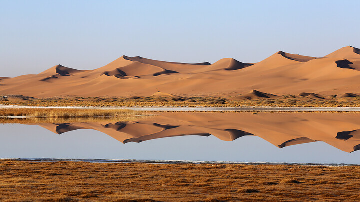 Dunes reflected in a still lake