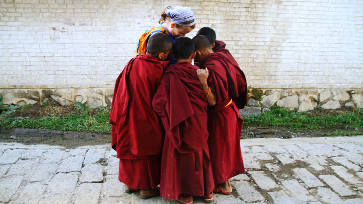 Young monks crowding for a look at a photo